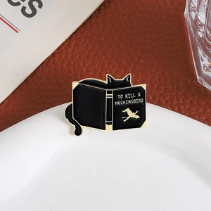 Enamel black cat book brooch featuring To Kill a Mockingbird design with gold robin