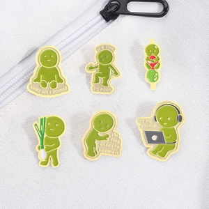 Detailansicht von sechs grünen Emaille-Pins auf weißem Canvas mit humorvollen Sprüchen