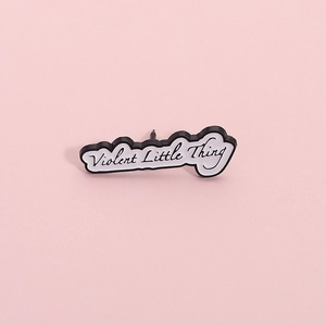 Enamel pin featuring Violent Little Thing text on a minimalist white background