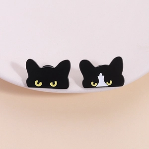 Set of two cute black cat enamel pins featuring yellow eyes on a white ceramic edge