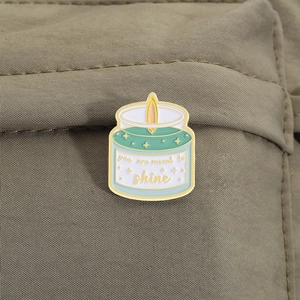 Detail of candle enamel pin with You Are Meant To Shine text on a canvas bag