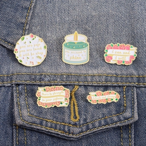 5-piece set of floral enamel pins with inspirational quotes on denim background