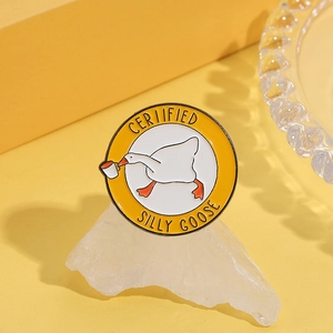 Detailed view of Silly Goose enamel pin with yellow border on a white stone base