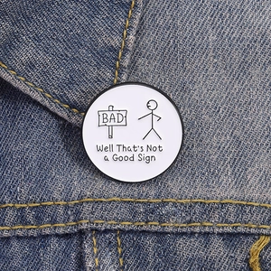 Badge humoristique en émail avec texte original épinglé sur une veste en jean
