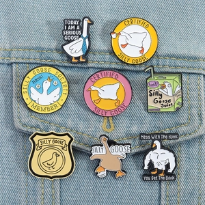 Detailed set of eight colorful silly goose enamel pins displayed on denim fabric