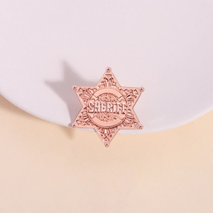 Rose gold sheriff badge brooch with hexagonal star shape and intricate scroll carvings