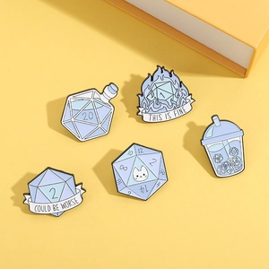Detail shot of five light blue D20 dice enamel pins set on a vibrant yellow background