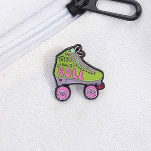 Detalle macro del pin esmaltado de patines verdes con texto 'This Is How I Roll'
