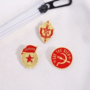 Dettaglio di spillette smaltate del KGB sovietico e badge Eat the Rich su tela bianca