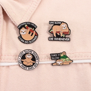 Detail of four funny enamel sloth pins featuring humorous quotes on pink denim fabric