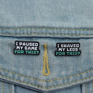 Funny enamel pins set on denim jacket featuring humorous phrases for gamers and lifestyle