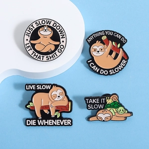 Close-up of four enamel sloth pins featuring humorous lifestyle quotes on blue background