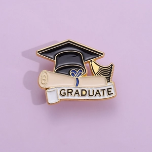 Detail view of enamel graduation pin featuring a black mortarboard and diploma scroll