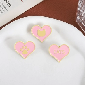 Lot de pins cœur en émail rose avec silhouettes de chat et bordure dorée sur assiette