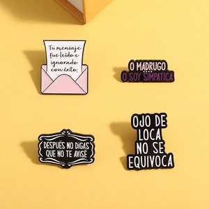 Lot de quatre pin's en émail coloré avec des phrases humoristiques en espagnol sur jaune