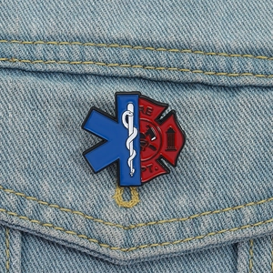 Dettaglio della spilla smaltata EMS Star of Life e vigili del fuoco su giacca di jeans