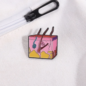 Detailed skin anatomy enamel pin with hair follicles shown on a white canvas bag