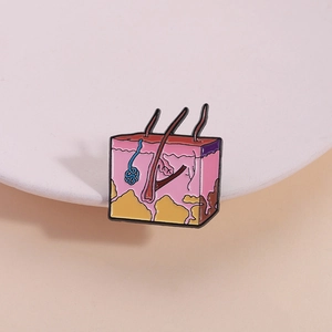 Creative skin anatomy enamel pin showing epidermis and hair follicle layers on white background