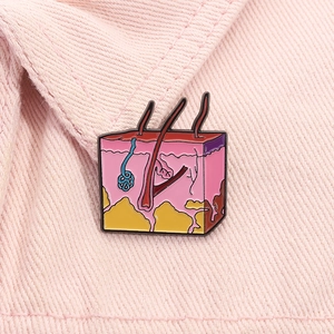 Macro shot of an enamel skin anatomy brooch showing detailed skin layers and hair follicle