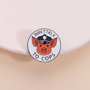 Cartoon pig sheriff enamel pin with Don't Talk to Cops slogan on a pink plate