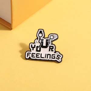 Close-up of enamel pin with Fuck Your Feelings stick figure text on yellow texture