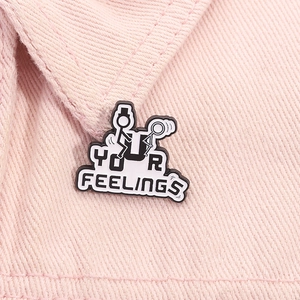 Macro shot of cartoon stick figure enamel pin with Your Feelings text on pink denim