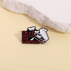 Macro view of vampire coffin enamel pin with small bats and gothic lettering