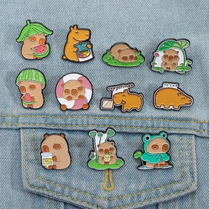 Collection of ten cute cartoon capybara enamel pins displayed on denim background