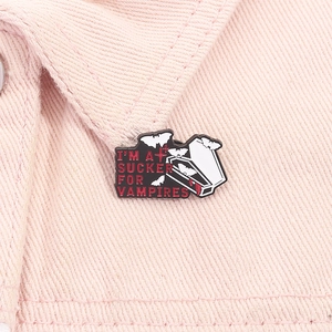Detail of horror enamel pin with vampire coffin and bats on pink denim jacket