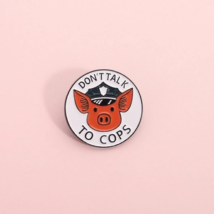 Round enamel badge featuring a pig in police hat and Don't Talk to Cops slogan