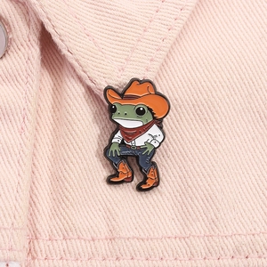 Détail d'un pin's émaillé de grenouille cowboy créative sur un revers de veste rose