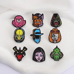 Set of 9 horror and monster themed enamel pins on a white ceramic tray for bags and hats