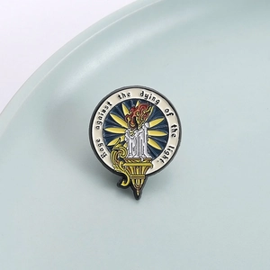 Macro d'un pin's émaillé avec un motif de bougie et une citation de motivation