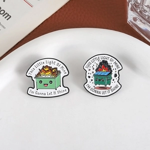 Cartoon burning trash can enamel pins with creative English quotes in a lifestyle setting