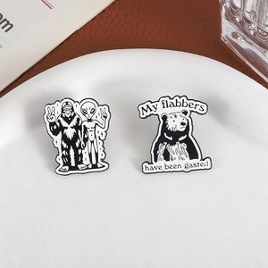 Lot de pins en émail noir et blanc avec alien bigfoot et ours sur une assiette blanche