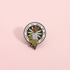 Enamel brooch featuring a lit candle and Rage against the dying of the light text