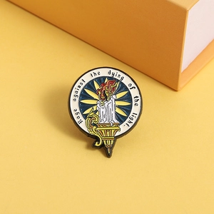 Broche en émail avec motif de bougie et citation Rage against the dying of the light