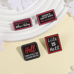 Gothic style enamel pins set with humor text on white pedestal with white flowers
