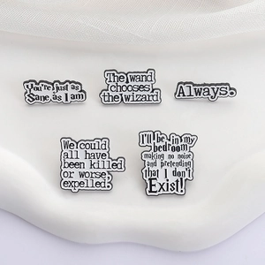 Set of five black enamel Harry Potter inspired pins featuring movie quotes on white stand