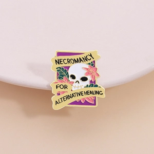 Detail of gothic enamel pin featuring a white skull with floral necromancy design