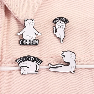 Détail de quatre épingles en émail de chats de yoga blancs sur denim rose avec texte