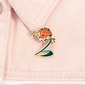 Close-up of a tiger lily enamel pin on a pink denim collar showing detailed floral craft