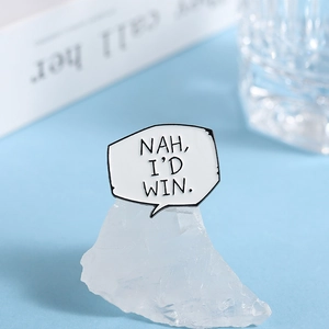 Macro shot of white enamel speech bubble pin featuring Nah I'd Win black text engraving