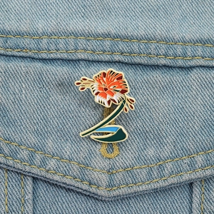 Artistic tiger lily fox enamel brooch with vibrant colors on blue denim fabric