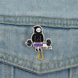 Funny fitness skeleton enamel pin featuring a weightlifting skull lifting weights on denim