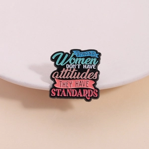 Enamel pin featuring Strong Women Don't Have Attitudes They Have Standards slogan