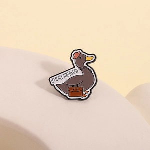 Broche en émail canard avec texte humoristique sur un support blanc élégant