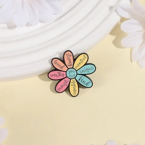 Colorful floral enamel brooch with motivational text on white display stand