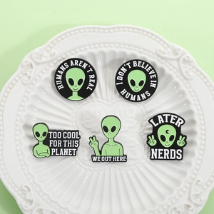 5-piece set of cartoon green alien enamel pins with punk skull and humor text on white plate