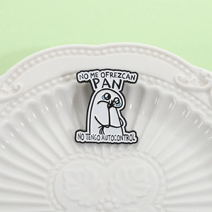 Detailed macro view of humorous Flork enamel pin on white ceramic plate with soft light